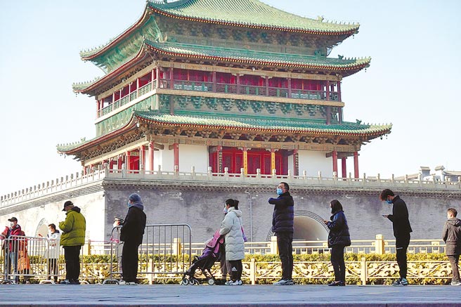 陝西西安開始對所有社區實施封閉式管理，每戶家庭每2天只能有1人外出採買。圖為市民排隊準備進行核酸檢測。（中新社）