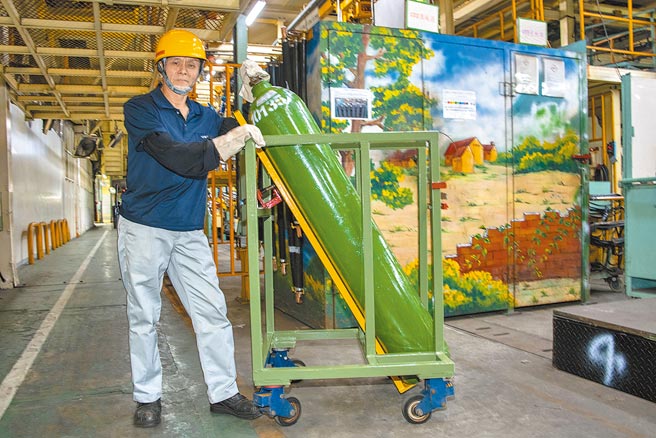 许慧龙示范钢瓶搬运省力化改善后的推车。（陈大任摄）