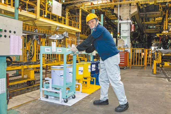 许慧龙示范可省力取用涂料桶重物的推车。（陈大任摄）