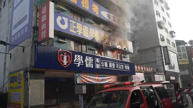 高雄市三民區學儒補習班大樓今上午傳火警，濃煙和火苗從2樓竄出，消防員在現場搶救。（翻攝照片／石秀華高雄傳真）
