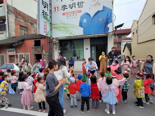 西螺鎮安定國小踩街隊伍經過校友縣議員李明哲服務處時，特別安排拉炮迎接，每個小朋友送一支拐杖巧克力！（周麗蘭攝）