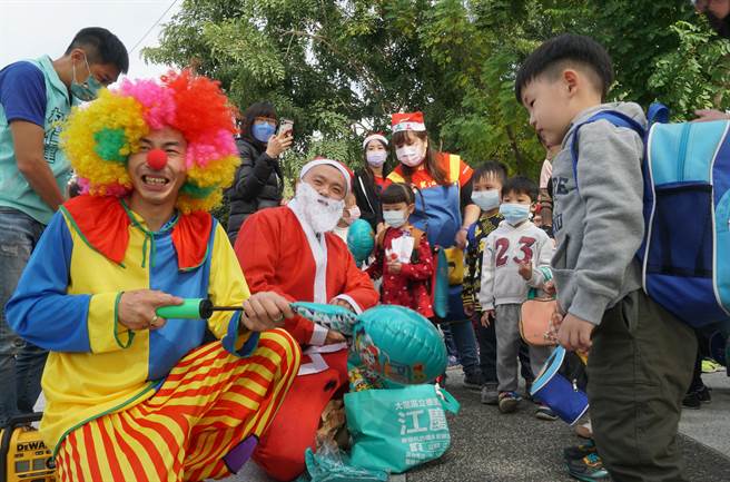 让警察很头痛的台中「跳舞哥」（左1）「改邪归正」了，24日他与立德里长江和树（左2），参与家扶非营利幼儿园的圣诞活动，扮小丑发气球，带给大家欢乐。（黄国峰摄）
