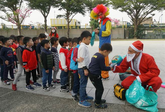 让警察很头痛的台中「跳舞哥」（右2）「改邪归正」了，24日他与立德里长江和树（右1），参与家扶非营利幼儿园的圣诞活动，扮小丑发气球，带给大家欢乐。（黄国峰摄）