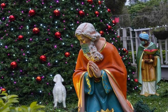 台北市天主教聖家堂聖誕樹旁帶著黃金、乳香、沒藥送禮給耶穌的三位東方賢士，全都戴上口罩。（黃子明攝）