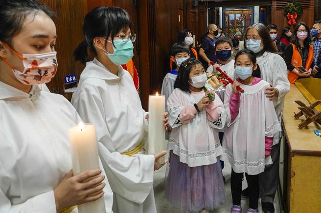 平安夜今晚在各地教堂登場，台北聖家堂耶誕彌撒儀式由饒志成神父主持，小朋友扛著耶穌像進場揭開序幕。（黃子明攝） 