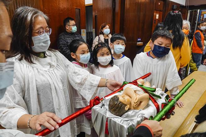 平安夜今晚在各地教堂登場，台北聖家堂耶誕彌撒儀式由饒志成神父主持，小朋友扛著耶穌像進場揭開序幕。（黃子明攝） 