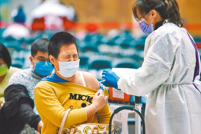 新冠疫苗「基礎加強劑」、「追加劑」，今起全面開放混打，圖為民眾前往台北車站大廳施打疫苗，露出痛苦表情。（鄧博仁攝）