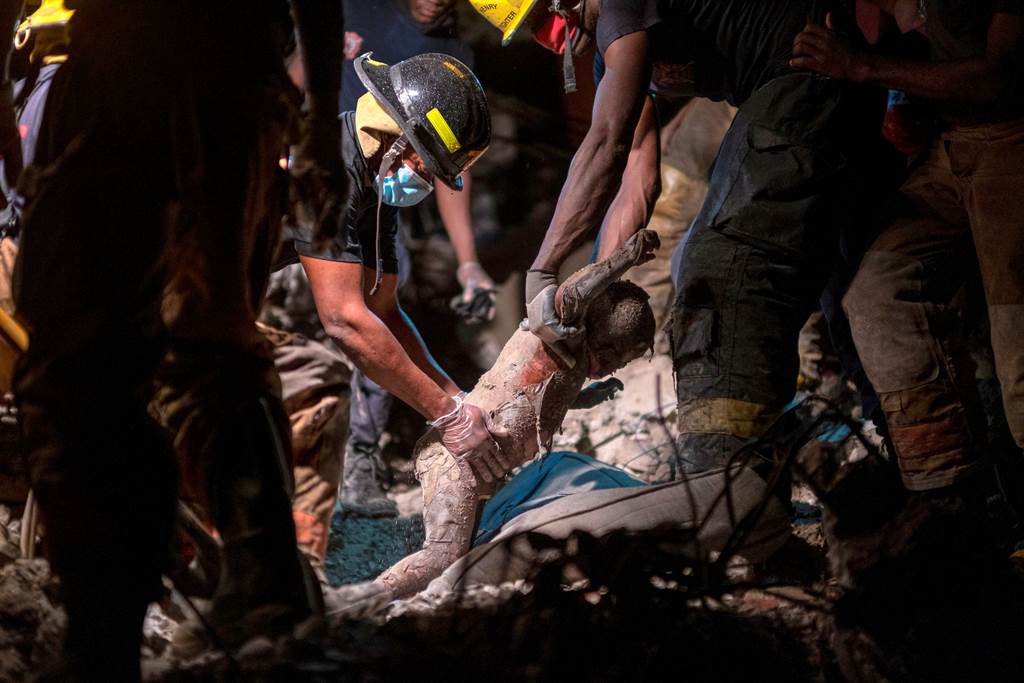 1名海地消防队员，自断垣残壁中找到3岁孩童的遗体。(图/路透社)(photo:ChinaTimes)