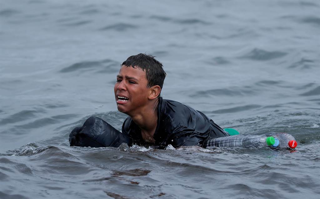 11月29日，1名摩洛哥男孩身上绑着空宝特瓶，试图游泳至西班牙。当他抵达海滩时，忍不住失声痛哭；他哭道，「我宁可死，再也不要回摩洛哥」。(图/路透社)(photo:ChinaTimes)