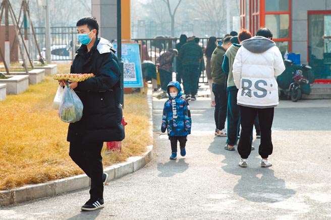 陝西省委書記劉國中強調，要加強價格監測，嚴厲打擊囤積居奇，保證老百姓的正常生活。圖為24日，西安某社區居民排隊領取配送的蔬菜。（中新社）