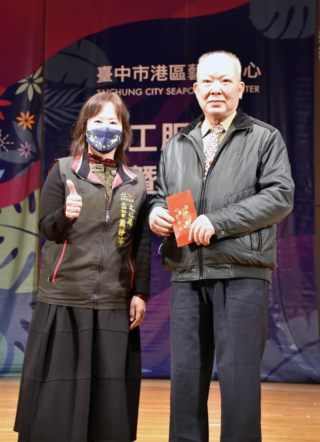 台中市文化局主任秘书萧静萍（左）颁奖给今年荣获卫生福利部志愿服务奖励金牌奖的纪忠男（右）。（王文吉摄）