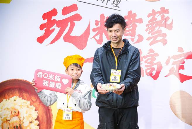 农委会农粮署举办「玩米煮艺一锅搞定-电锅饭料理」竞赛，小小厨师开心上台，帮爸爸的料理举牌打气。（罗永铭摄）