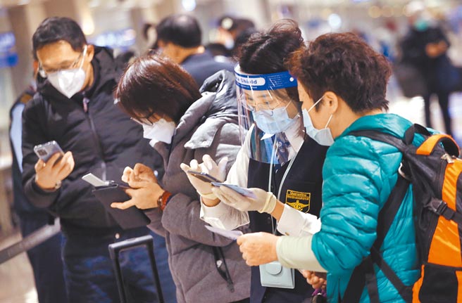 衛福部長陳時中表示，新冠疫情發展於明年春節後應會更明朗化。圖為桃園機場人員協助旅客登錄入境檢疫資料。（范揚光攝）