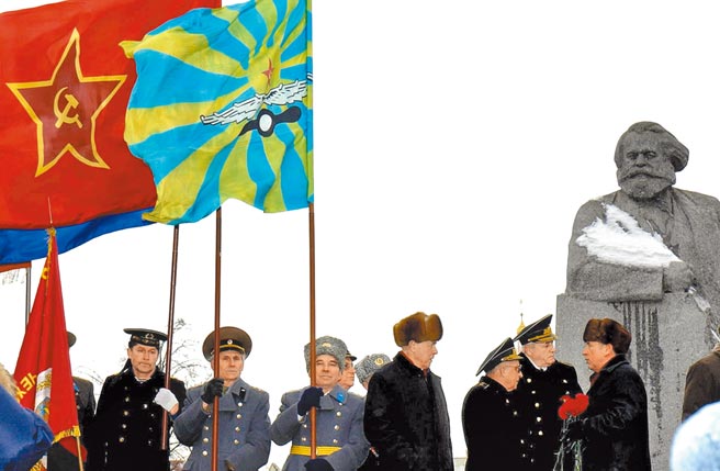2004年2月23日，在俄羅斯首都莫斯科劇院廣場（原馬克思廣場）的馬克思雕像前，一些民眾穿著軍服，手擎前蘇聯旗幟參加紀念集會。（新華社）