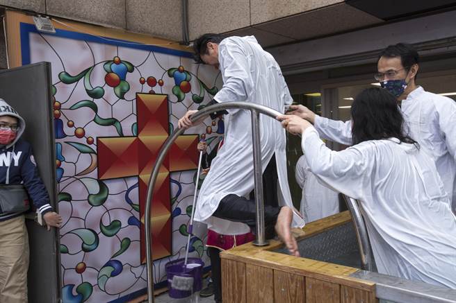 教友冒著低溫天候在戶外以浸水禮完成洗禮，跨出受洗池迎向十字架。（黃子明攝）