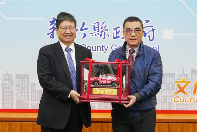 超昱光電科技董事長劉宏洋（右）捐贈1輛約120萬元的災情勘查車，縣長楊文科（左）頒發琉璃獎盃與災情勘查車模型作為回禮。（羅浚濱攝）