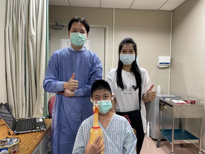 男童在今年5月接受人工电子耳植入微创手术，后，启动电子耳后重获听觉，开心地与主治医师温惟升合影。（中山附医提供／冯惠宜台中传真）
