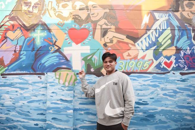 旅美球星李灏宇在艺术墙上画出十字架，并表示能够让他凭着信心去面对挑战就是信仰。（国泰金控提供）