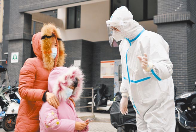 大陆陕西省西安市疫情持续严峻，单日新增150例新冠本土病例。图为西安防疫人员27日引导民眾做普筛。（新华社）