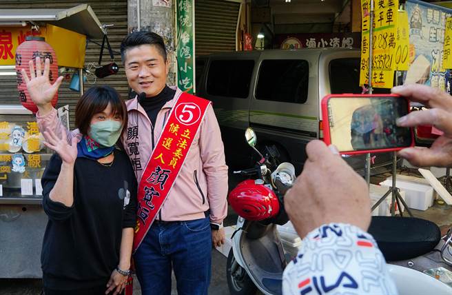 台中第二選區立委補選，國民黨候選人顏寬恒29日上午到烏日區明道花園城市場拜票，有民眾開心要求合照。（黃國峰攝）