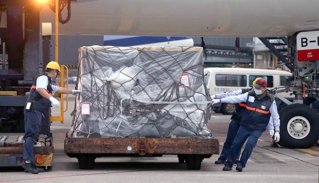 民间团体共同捐赠的第15批93.83万剂BNT疫苗，30日清晨运抵桃园机场，地勤人员将装载疫苗的货盘卸下。（范扬光摄）