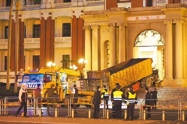 2014年间，驾驶张德正因认为「司法不公」，便开着一辆35吨砂石车从凯道跨越重庆南路直衝总统府，车头全毁，张德正则手脚骨折昏迷送医院救治。图为警方当时调请拖车将砂石车就地拆解拖离。（中时资料照／杜宜谙摄）