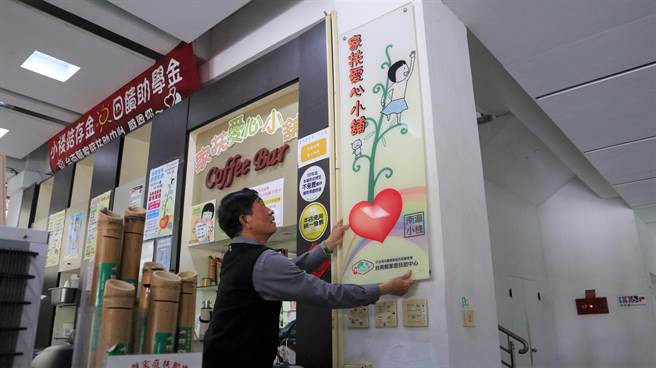 爱心小舖今天熄灯，当初一手创立小舖的前家扶基金会副执行长周明泉今天亲自将招牌拆下。（张毓翎摄）