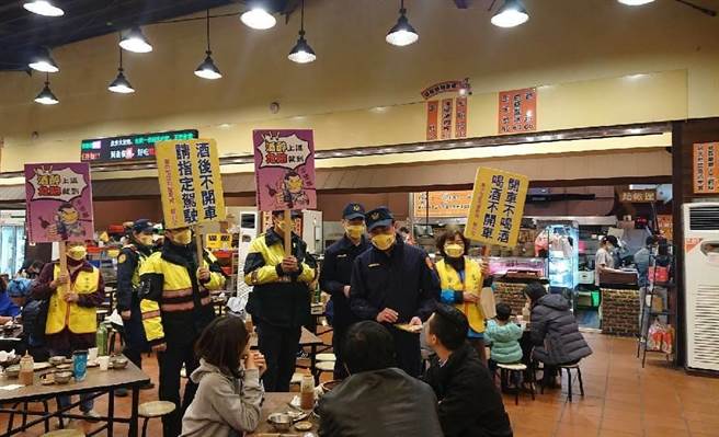 員警偕同志工媽媽手持宣導標語，提醒用餐民眾「酒後勿開車、指定代理駕駛才是安全的回家路」。（民眾提供／盧金足台中傳真）