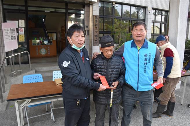 头份市永贞宫2021年寒冬送暖活动，30日首先在三湾乡公所举行，三湾乡长温志强（左）到场协助发放。（谢明俊摄）