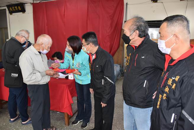 头份市永贞宫2021年寒冬送暖活动，31日在永贞宫活动中心举行，主委张淑芬（左二）亲自发送慰助金给弱势民眾。（谢明俊摄）