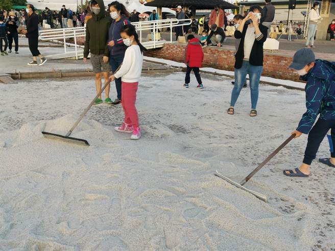 小朋友在盐田体验晒盐。（刘秀芬摄）