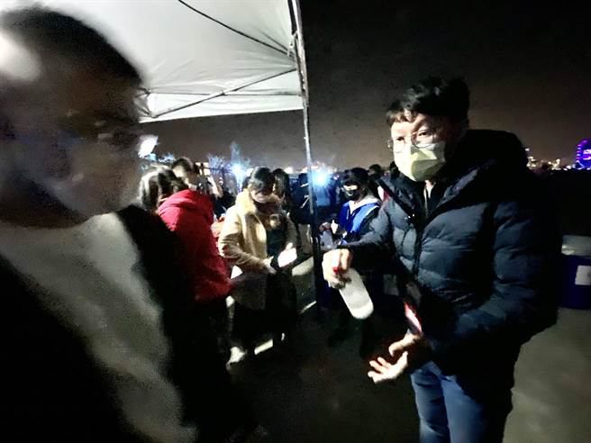 台中跨年晚会愈晚人潮愈多，扇形的6个入口大排长龙，台中市府新闻局长黄国玮（右）也上阵为民眾喷洒酒精。（卢金足摄）