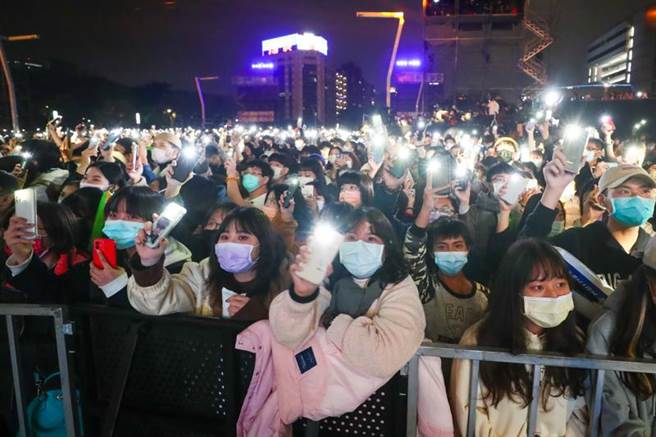 「台北最HIGH新年城–2022跨年晚会」31日晚间热闹登场，现场越夜越热闹，民眾配合点亮手机灯光，随着音乐旋律摇摆，期待新年倒数时刻。(图/中央社)