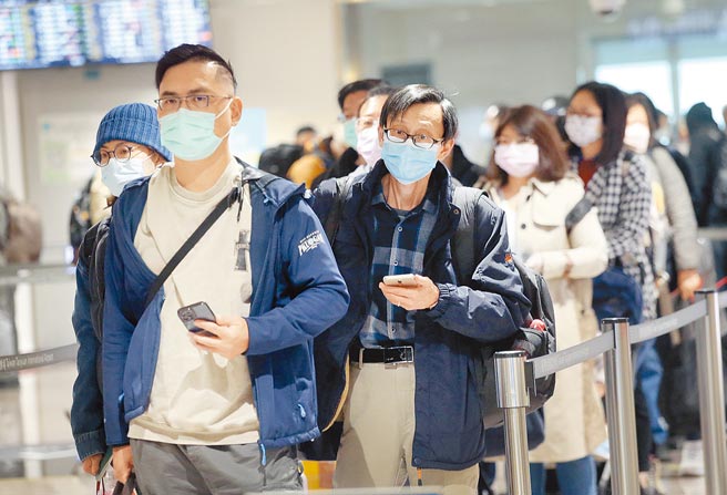 中央流行疫情指揮中心31日公布國內新增41例新冠肺炎境外移入確定病例，創下國內疫情史上境外移入新高。在桃園機場入境管制區內，剛下機的旅客排隊查驗入境檢疫資料。（范揚光攝）（圖中非新聞當事人）