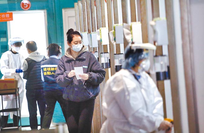 北市防疫旅馆3人染疫案，中央流行疫情指挥中心发言人庄人祥昨天表示，已完成案17058的基因定序检验，确认为Omicron变异株，另两名个案结果最快今天公布。图为桃园机场第二航厦外的採检站，刚入境的旅客依序入内採检。（范扬光摄）（图中非新闻当事人）