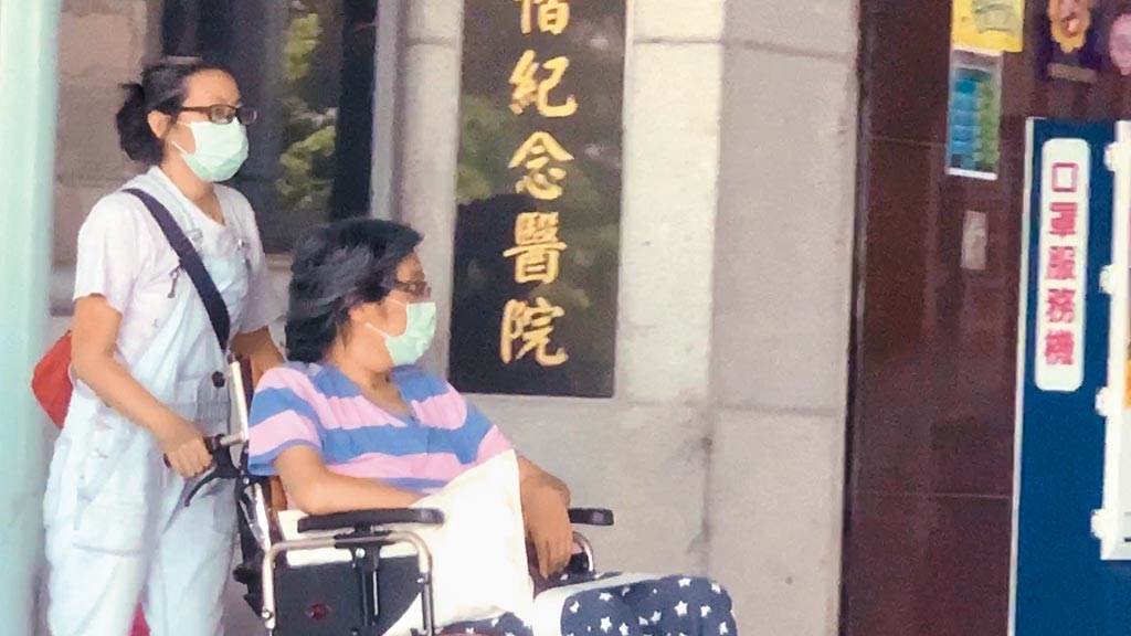 袁惟仁（右）去年8月被目擊坐著輪椅出現在台東馬偕醫院看診。（讀者提供）