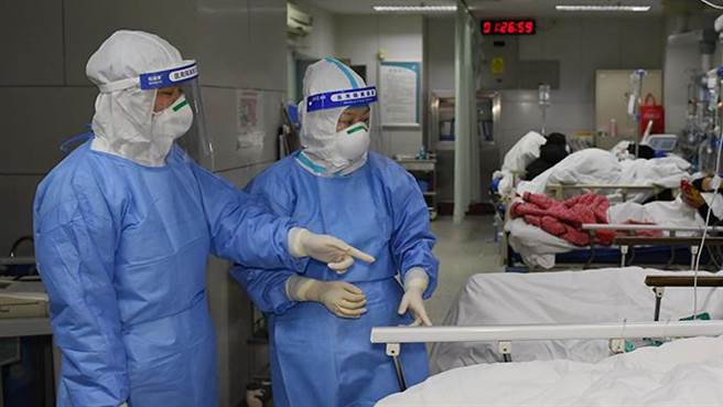 今年1月1日凌晨，西安交通大學第二附屬醫院急診科醫生鄭少微（左）向護士樊鑫安排急診患者治療方案。（圖／新華社）