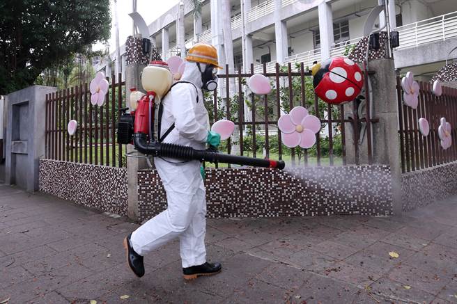 個案17181曾赴北市某國小附設幼兒園接小孩，該幼兒園3日起需停課2天。北市環保局人員2日赴該國小周邊執行環境清消，確保病毒不會擴散。（黃世麒攝）