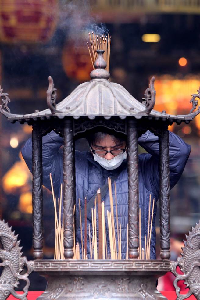 民眾在新庄武圣庙捻香参拜，清代建庙的起因，是在地商家多膜拜关圣帝君，可见当地商业鼎盛。（黄世麒摄）