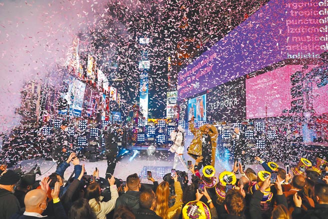 全球在Omicron变种病毒疫情阴影下步入2022年。图为2021年12月31日跨年夜，许多美国民眾聚集在纽约时报广场，观看歌手在台上卖力表演。（路透）