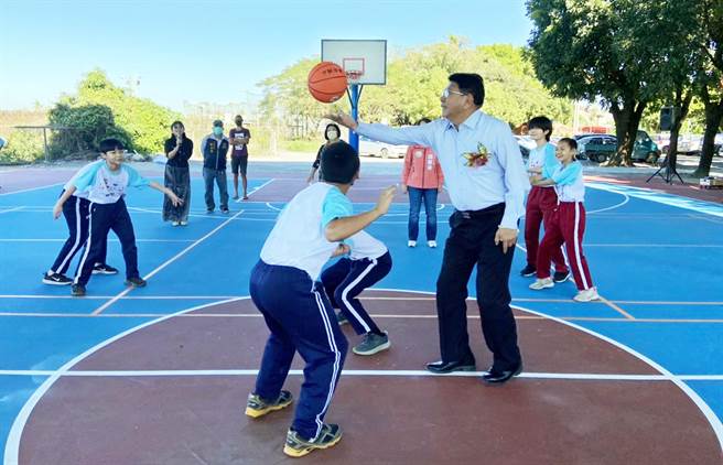 曾面临裁併校危机的高树乡新南国小，迎接半户外球场落成，由屏东县长潘孟安（右）为学生开球。（林和生摄）