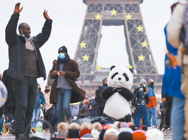 法国连4天单日新增新冠确诊病例超20万例，图为在巴黎铁塔附近广场，一名小贩打扮成大熊猫玩偶的模样招揽顾客。（新华社）