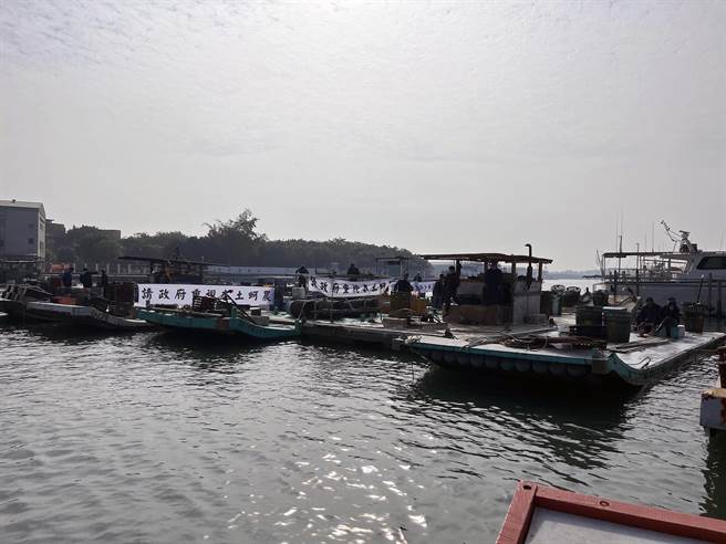 台南沿海蚵农驾胶筏前往台南市区渔会前的安平渔港海域，要求政府提出解决方案，保障本土养蚵产业。（洪荣志摄）