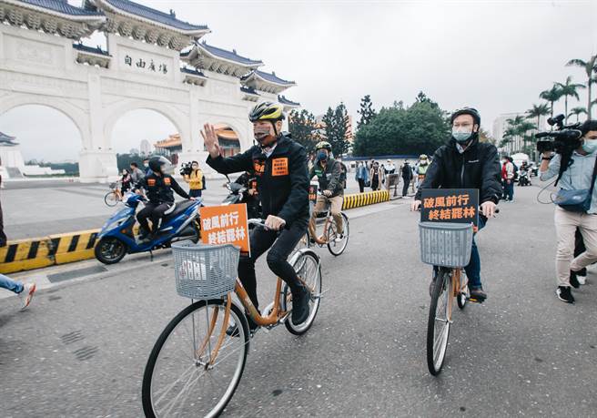 立法委员林昶佐（前）与民进党副秘书长林飞帆（后）4日在北市以单车扫街，沿途向路过民眾挥手致意。(郭吉铨摄)