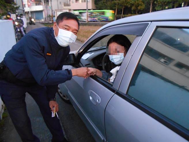 王女感謝大里分駐所員警，號召民眾幫忙將陷在田埂的車輪推回路面，向員警握手道謝。（霧峰分局提供／黃國峰台中傳真）