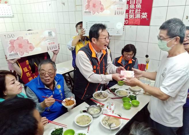 屏东市民代表会主席萧国亮（中）到夜市品尝小吃，用消费券刺激经济。（林和生摄）