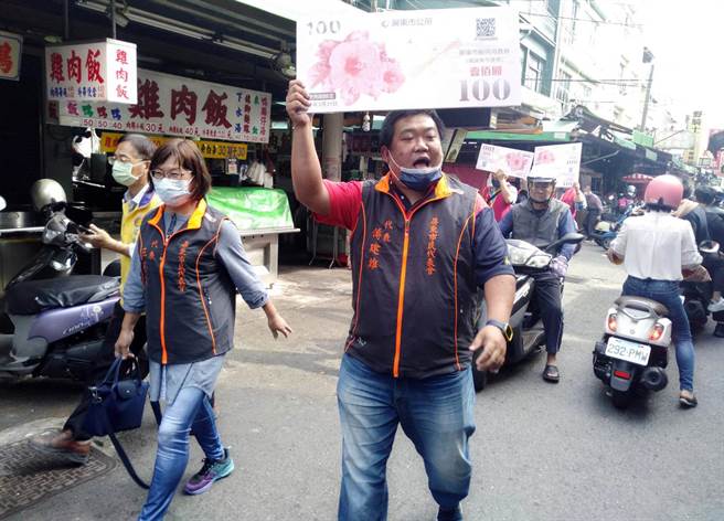 为加强消费力道，民代鼓励店家收取消费券，一同振兴屏东市经济。（林和生摄）