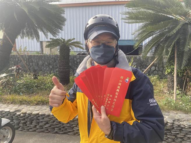 台东县关山镇4日起发放每位镇民2000元防疫礼金，镇民拿着红包开心拍照留念。（蔡旻妤摄）