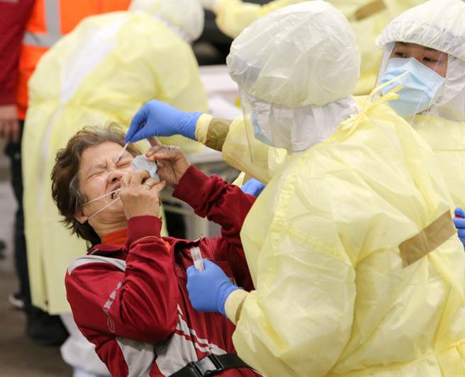 採檢人員以插鼻孔的方式採檢，清潔員臉上顯現不舒服的表情。（陳麒全攝）