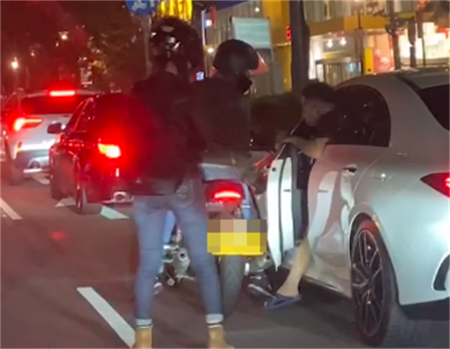 宾士驾驶准备下车理论时，没想到下秒竟遭重机车身「挡住车门打不开」，他一度将脚伸出车外仍推不开车门。（翻摄自记者爆料网）